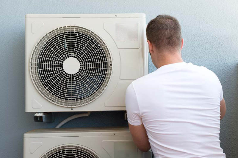 Male technician installing air-conditioning system, AC Maintenance