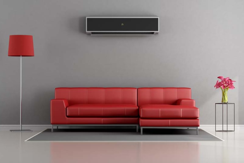 Planning to Remodel? Go Ductless! Living room with red sofa and air conditioner.