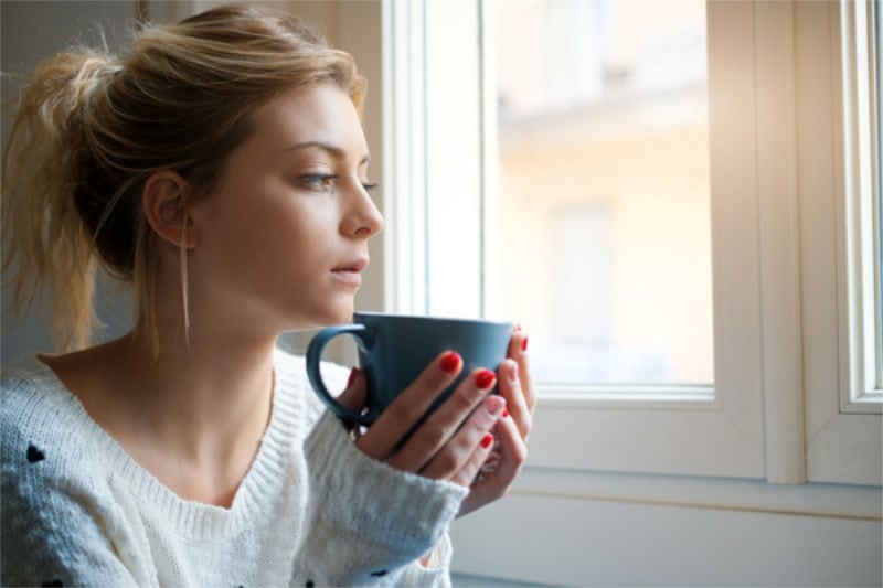 Girl feeling in a bad mood and drinking hot drink