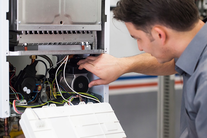 HVAC technician performing maintenance on a heat pump.