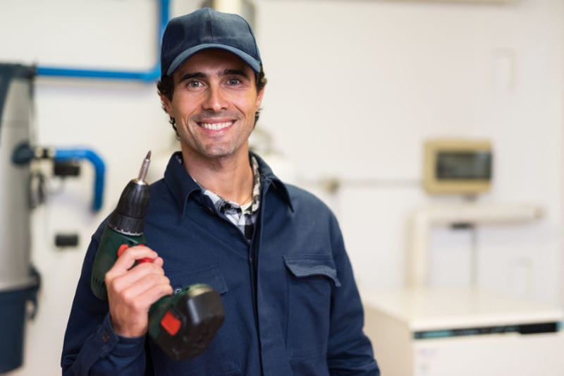 Smiling worker holding a screwdriver